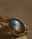 Natural-stone ring resting on a warm stone surface