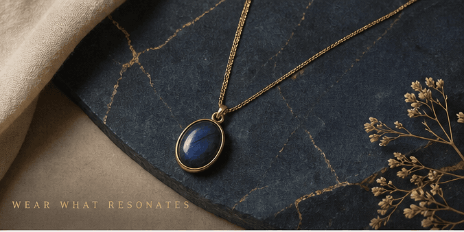 Gold necklace with a deep blue natural stone on dark veined stone